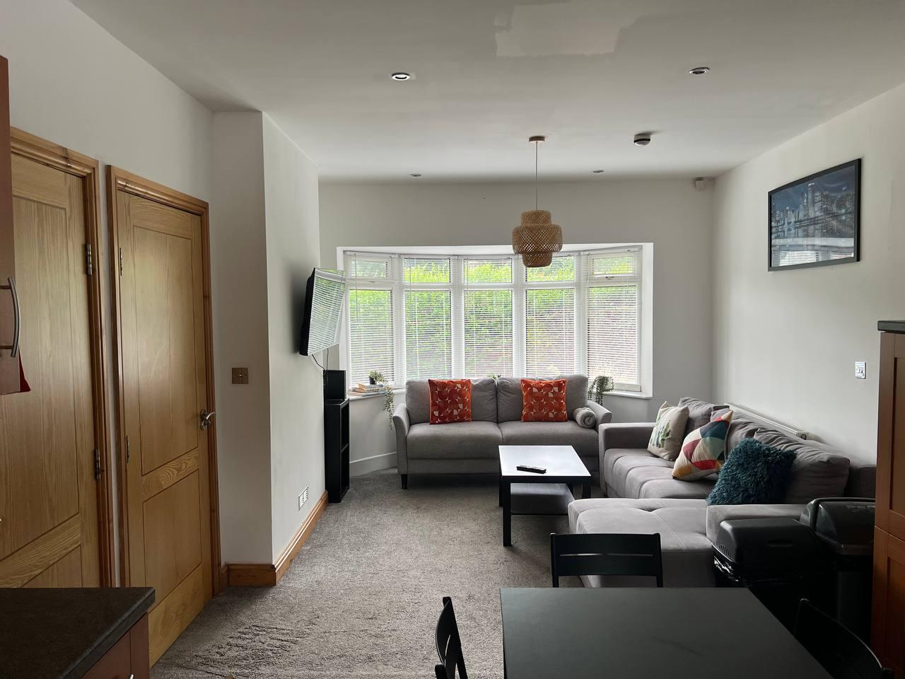 Lounge with corner sofas opening onto the kitchen — Greenhead Road, Huddersfield