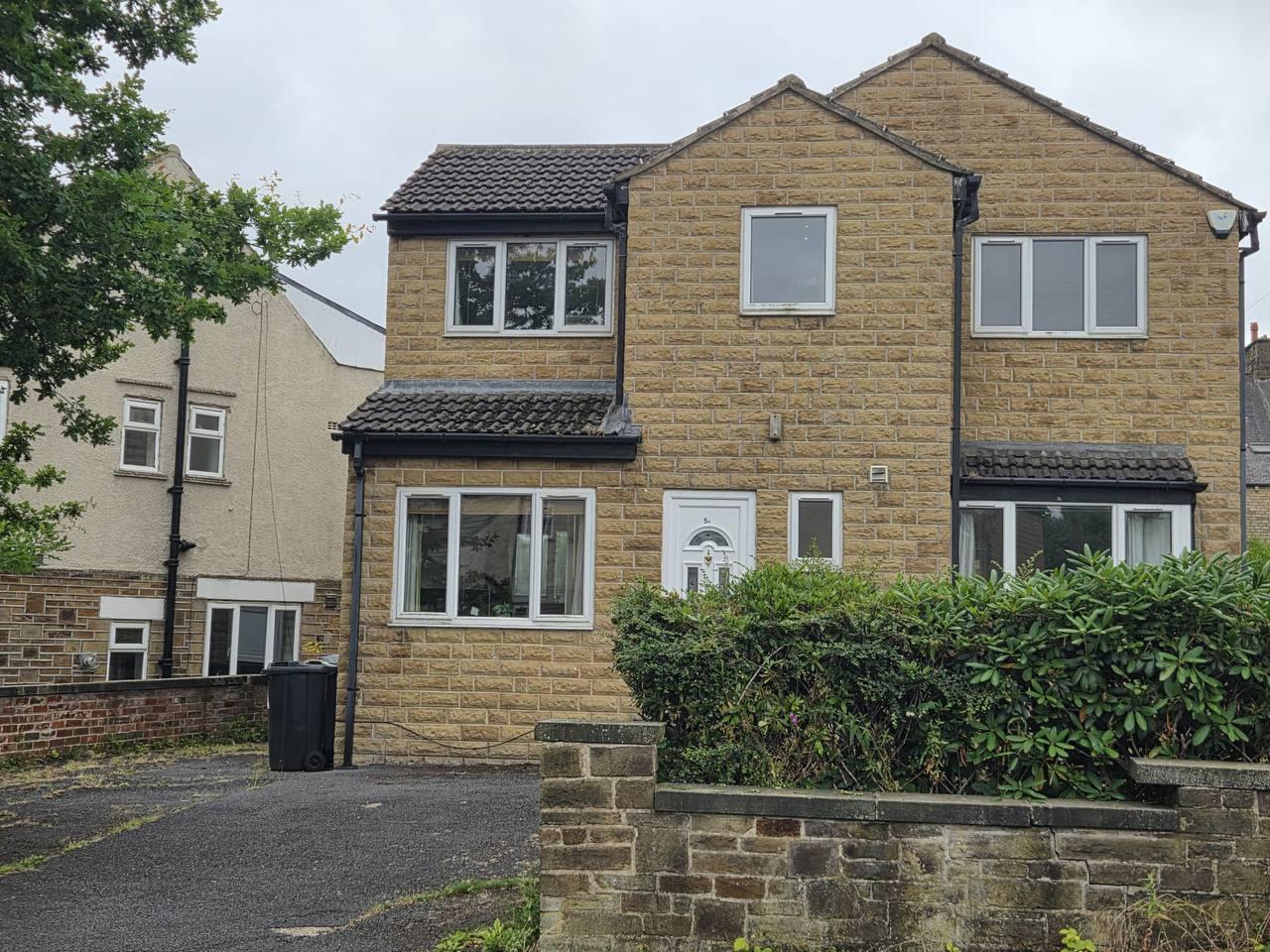 Front exterior and driveway parking at Lynton Avenue 5a, a stone-built house in Huddersfield
